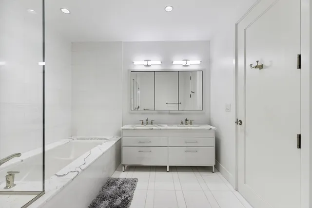 a bathroom with a granite countertop bathtub shower sink and mirror