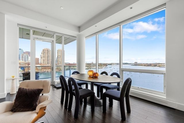 a dining room with furniture large windows and wooden floor
