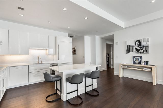 a view of a kitchen with kitchen island stainless steel appliances refrigerator stove microwave and cabinets