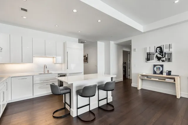 a view of a kitchen with kitchen island stainless steel appliances refrigerator stove microwave and cabinets