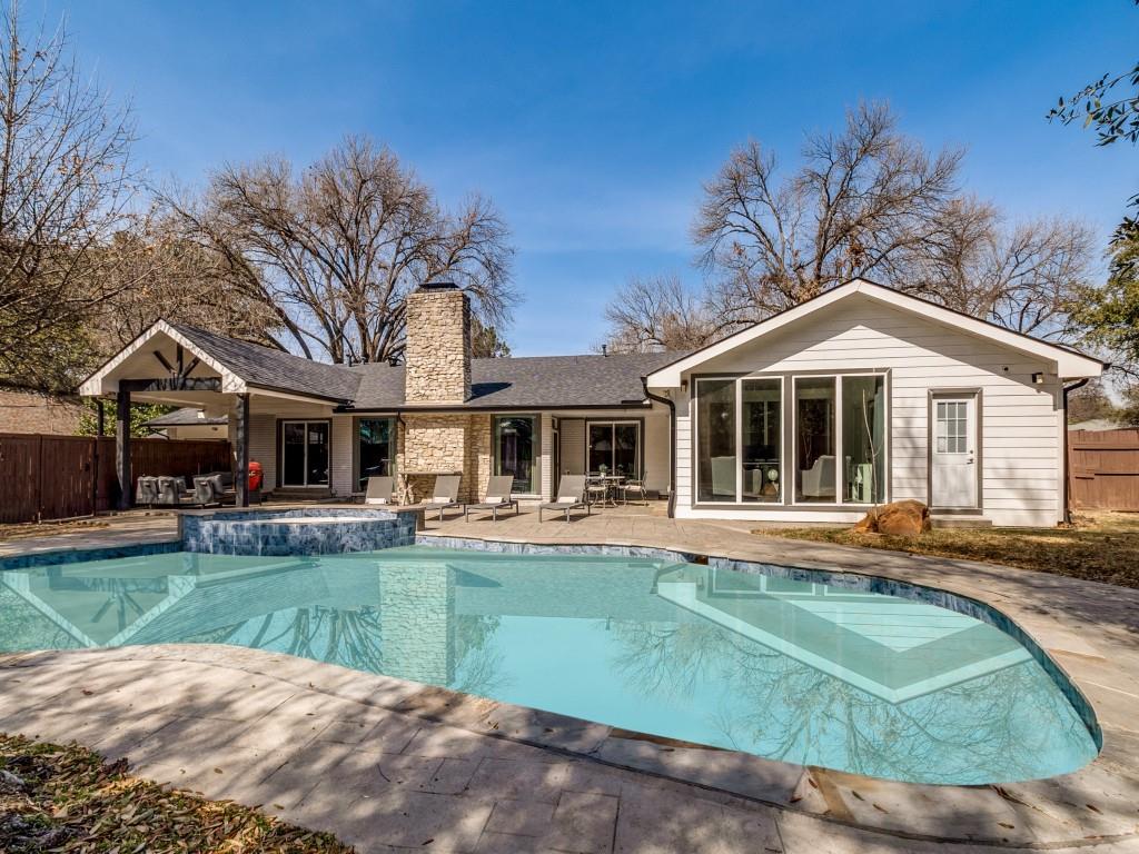 7326 Spring Valley Road Dallas, TX 75254 - Photo 23 of 25 Back of property featuring a patio area, a chimney, and a pool with connected hot tub