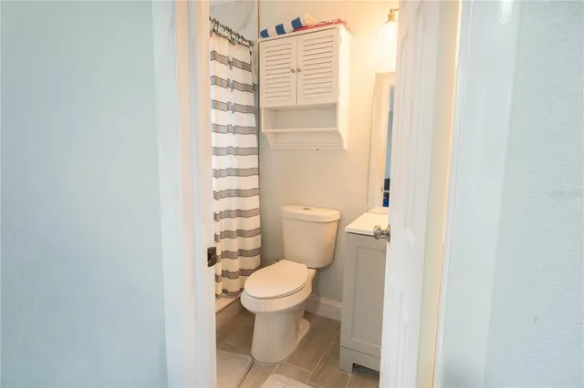 a white toilet sitting next to a shower curtain