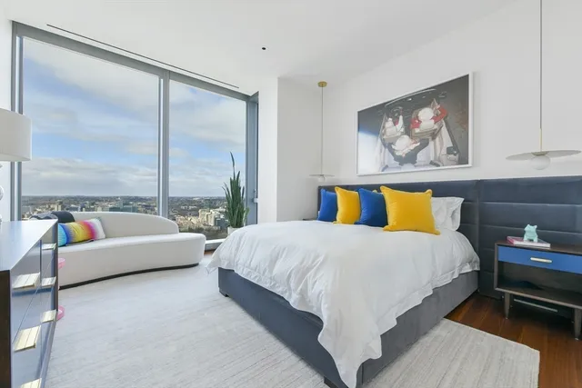 a large bed sitting in a bedroom next to a window with couch