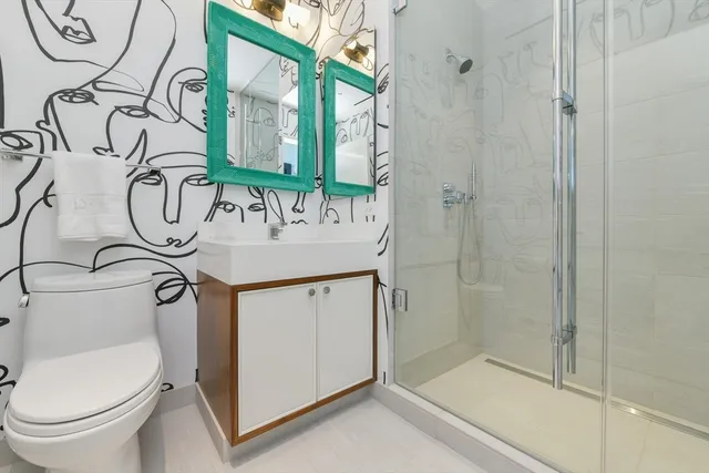 a bathroom with a granite countertop sink a toilet and a shower