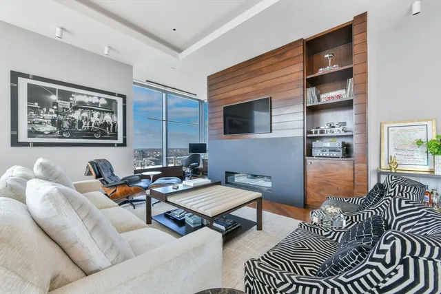 a living room with furniture a rug and wall paintings