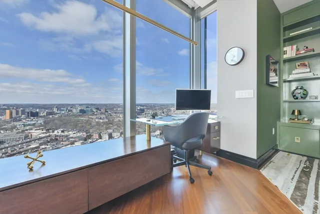 a view of a workspace with furniture and wooden floor