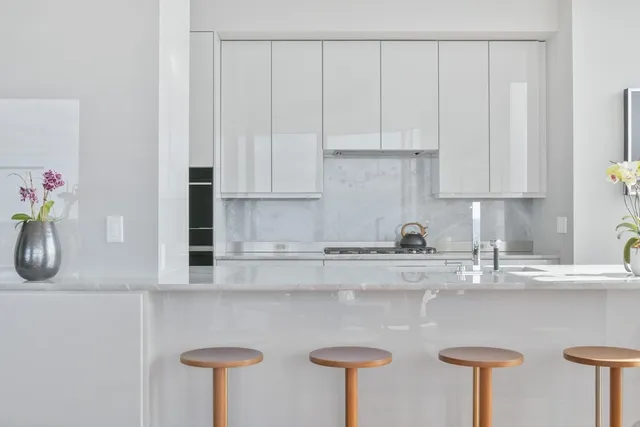 a kitchen with stainless steel appliances granite countertop a sink a stove and white cabinets