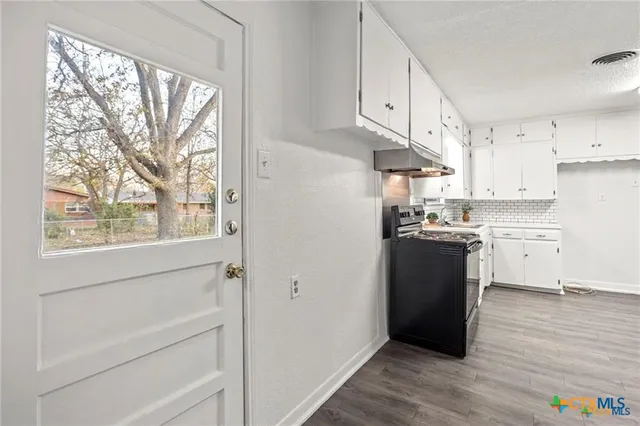 a stove top oven sitting inside of a kitchen