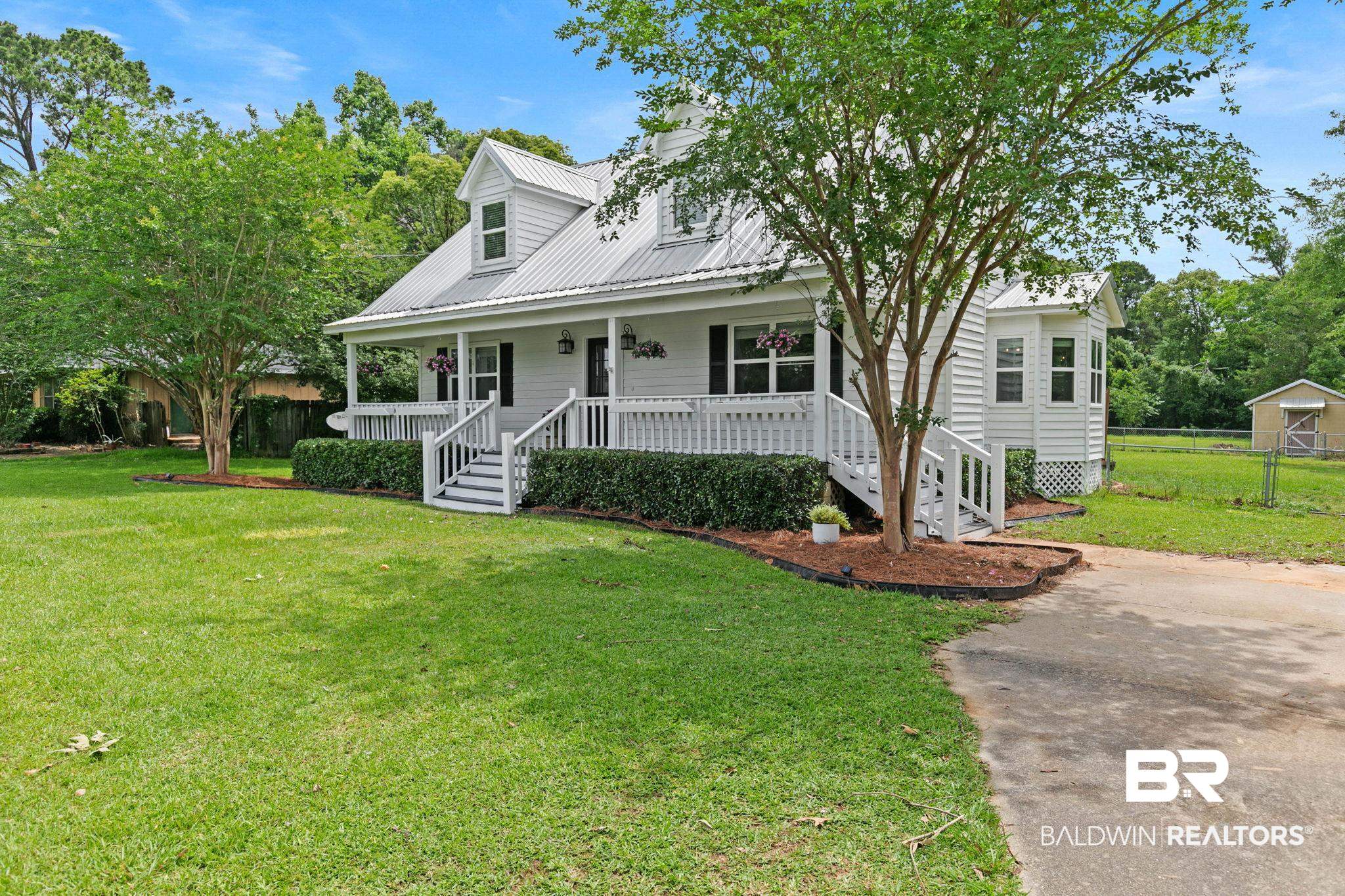 22810 High Ridge Road Fairhope, AL 36532 - Photo 14 of 78 White siding residence with a metal roof and an expansive front porch featuring white railings