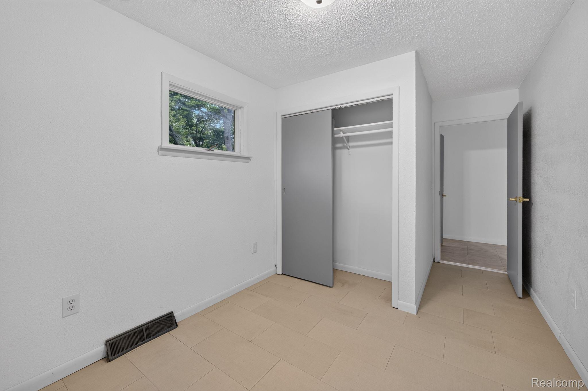 9288 Hilda Lane Flushing, MI 48433 - Photo 35 of 50 Room featuring light-toned tile flooring, a window, and a closet with sliding panel doors