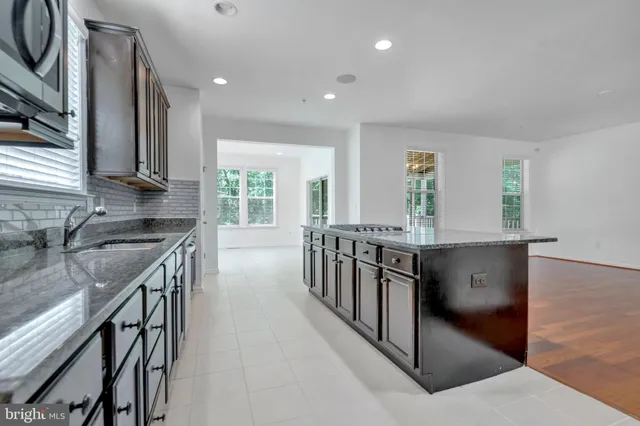a kitchen with stainless steel appliances granite countertop a stove microwave and cabinets