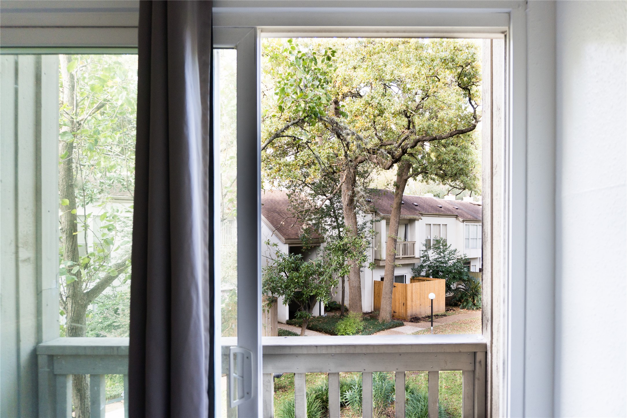 2100 Tanglewilde Street, Unit 455 Houston, TX 77063 - Photo 28 of 37 The view from the primary of lush green trees and landscaping.