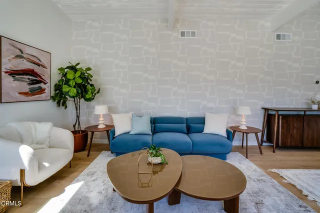 a living room with furniture a fireplace and a floor to ceiling window