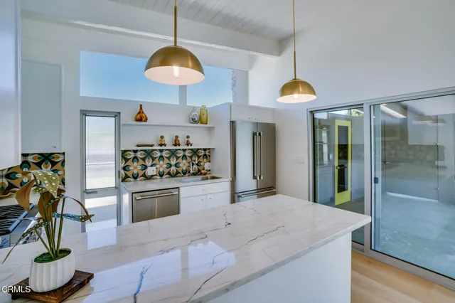 a kitchen with stainless steel appliances kitchen island granite countertop a stove a sink and a refrigerator