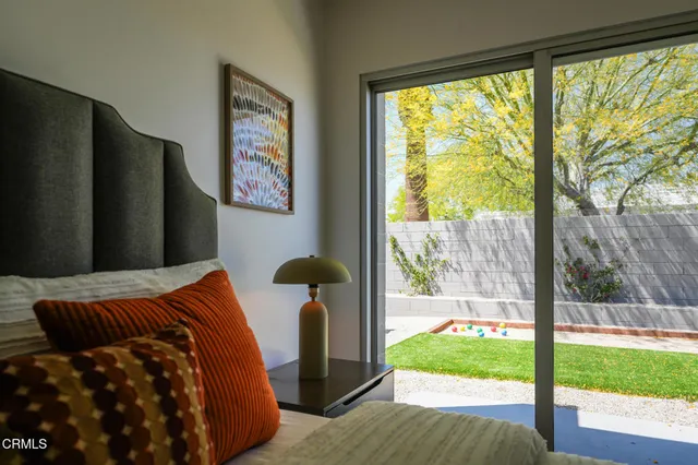 a bedroom with furniture and a large window