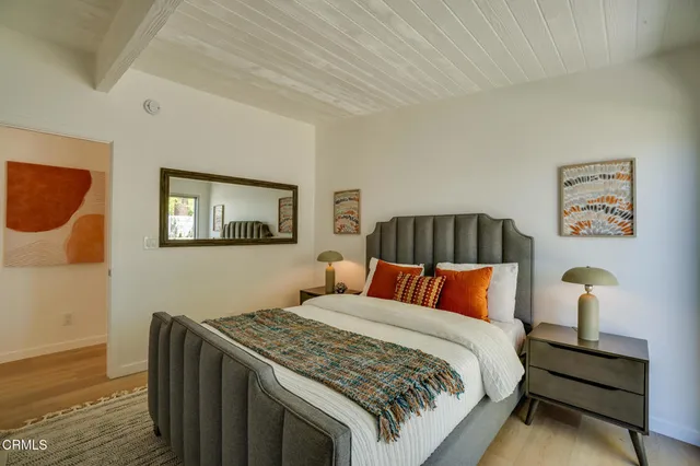 a bed sitting in a spacious bedroom next to a window