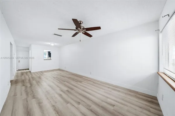 wooden floor in an empty room with a window