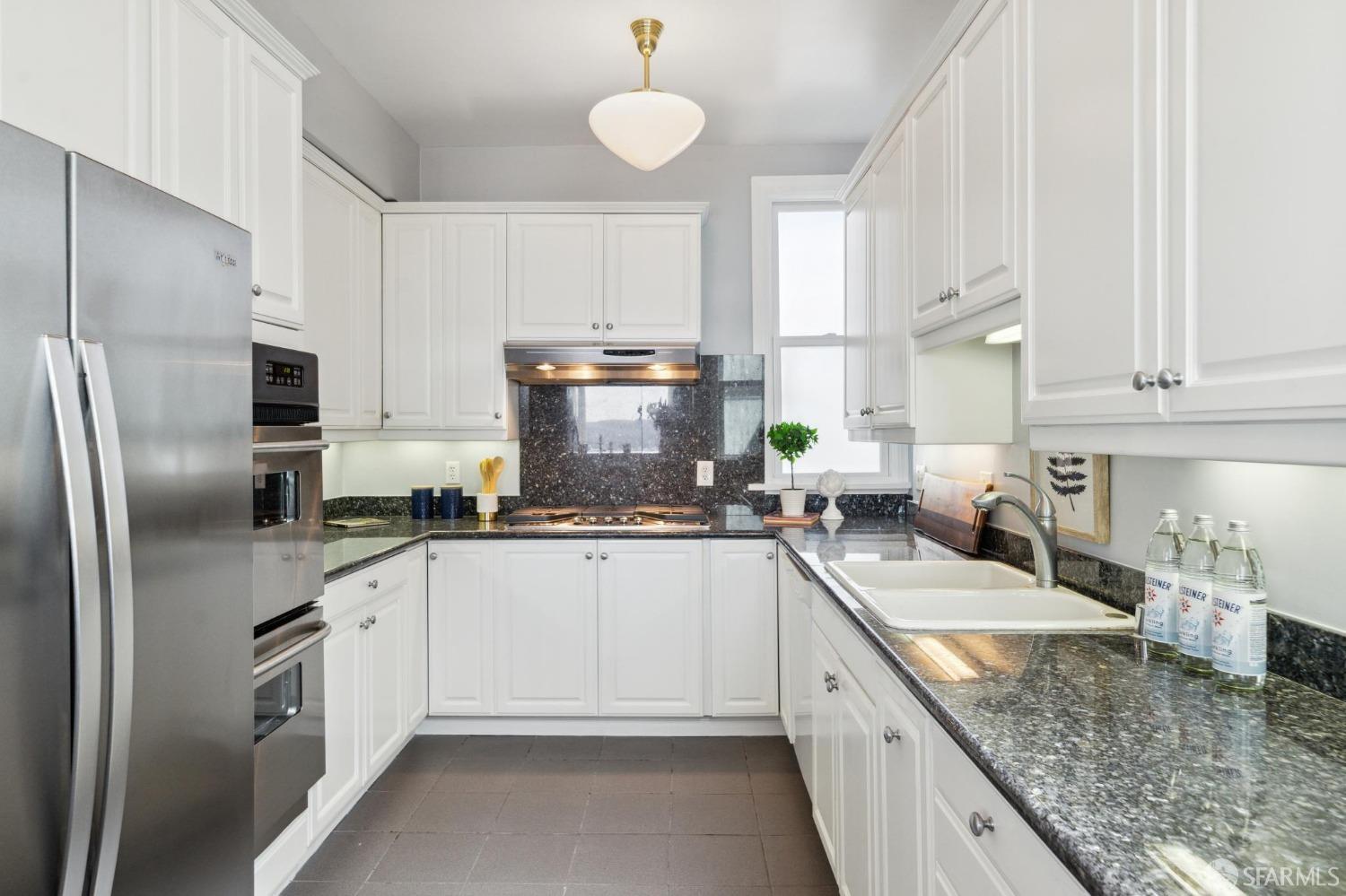 2421 Larkin Street San Francisco, CA 94109 - Photo 11 of 29 a kitchen with stainless steel appliances granite countertop a sink stove refrigerator and cabinets