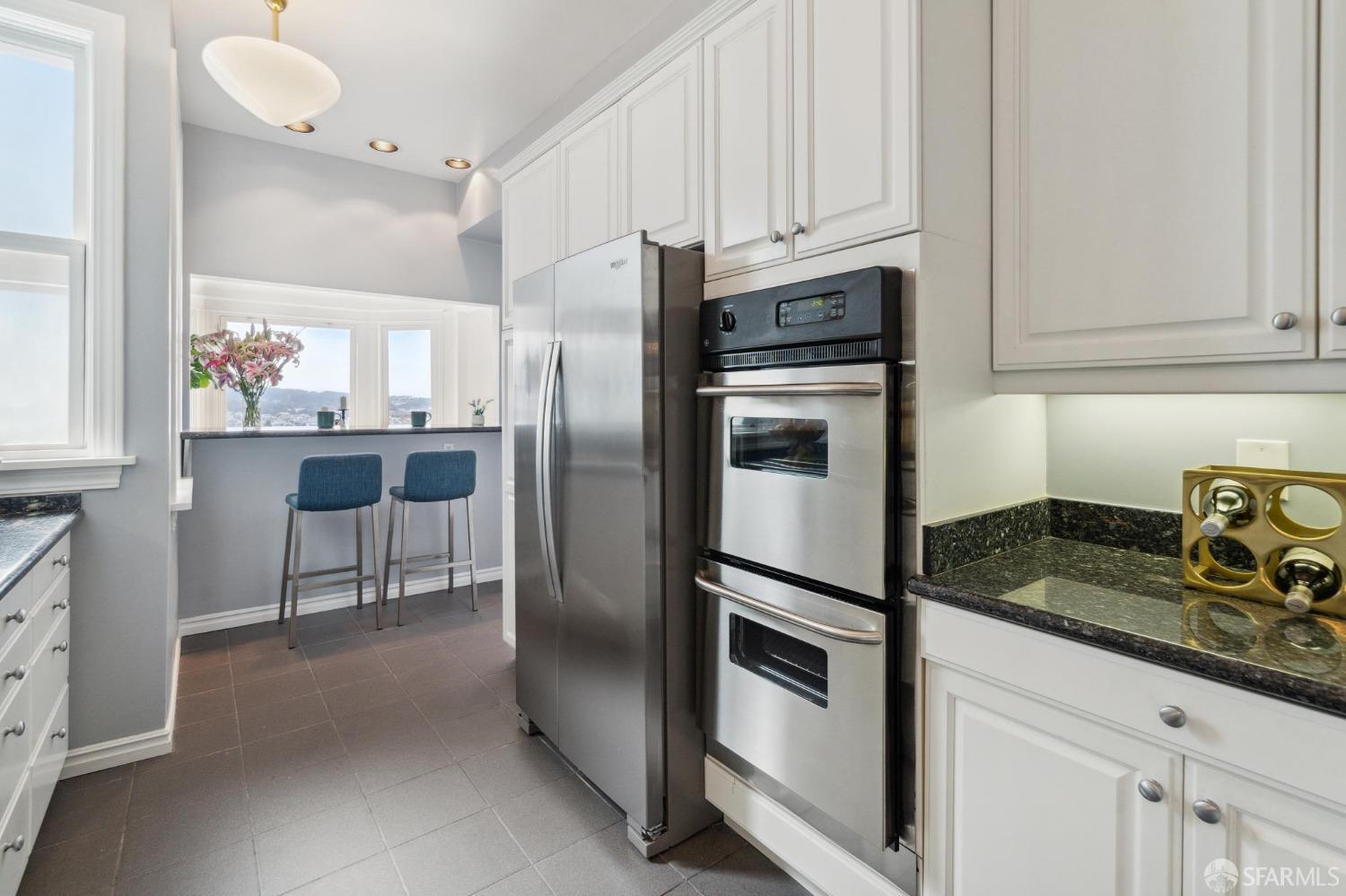 2421 Larkin Street San Francisco, CA 94109 - Photo 12 of 29 a kitchen with granite countertop a refrigerator stove and sink