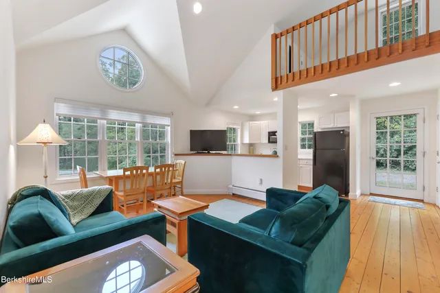 a bedroom with a bed and two window