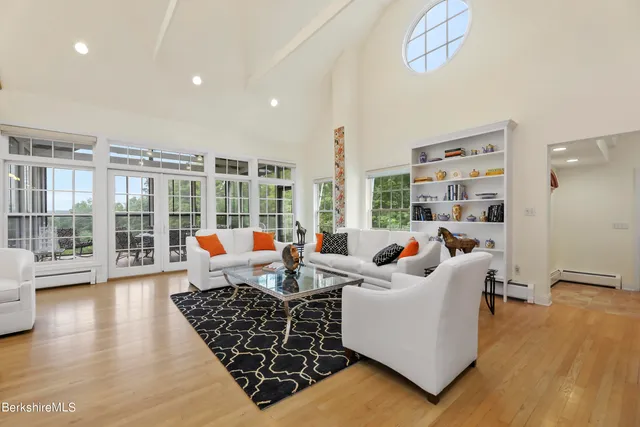 a living room with furniture floor to ceiling window and wooden floor