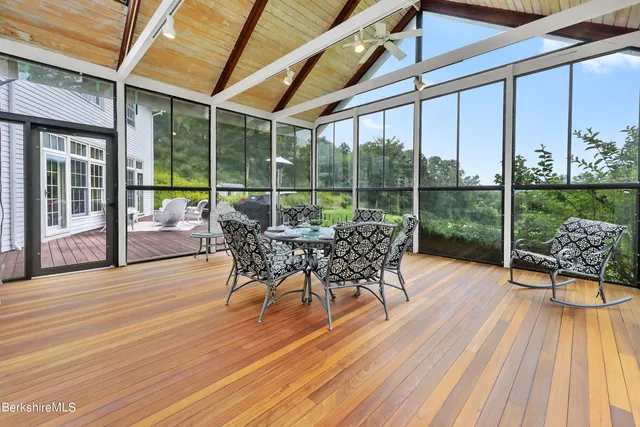 a dining space with wooden floor and outdoor space