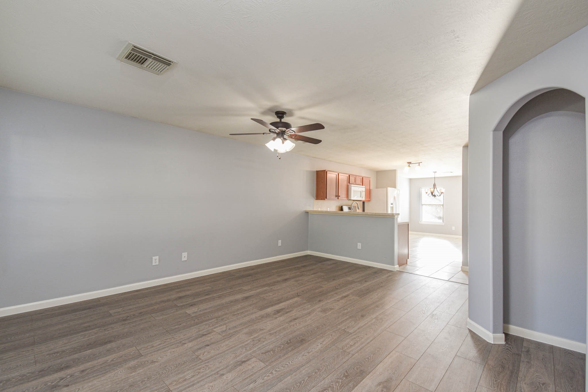 8203 Nagy Hill Street Spring, TX 77379 - Photo 4 of 21 a view of a livingroom with wooden floor and a ceiling fan
