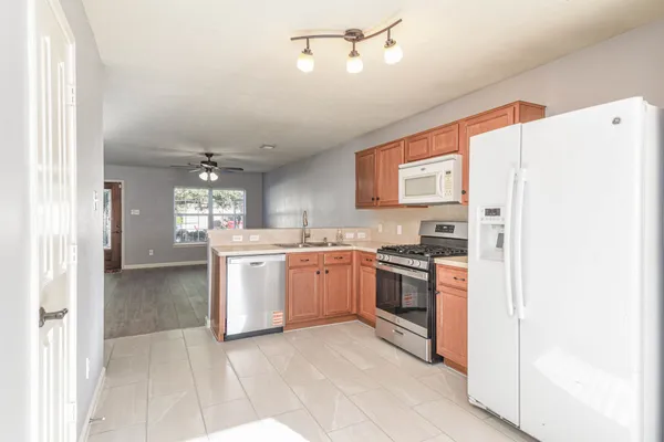a kitchen with a refrigerator a stove top oven and cabinets