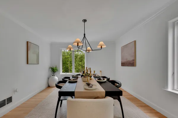 a dining room with furniture a chandelier and wooden floor