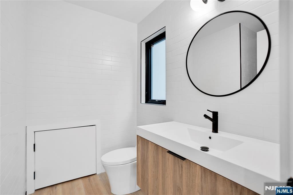 7 Adelaide Place Edgewater, NJ 07020 - Photo 11 of 24 a bathroom with a sink a toilet and a mirror