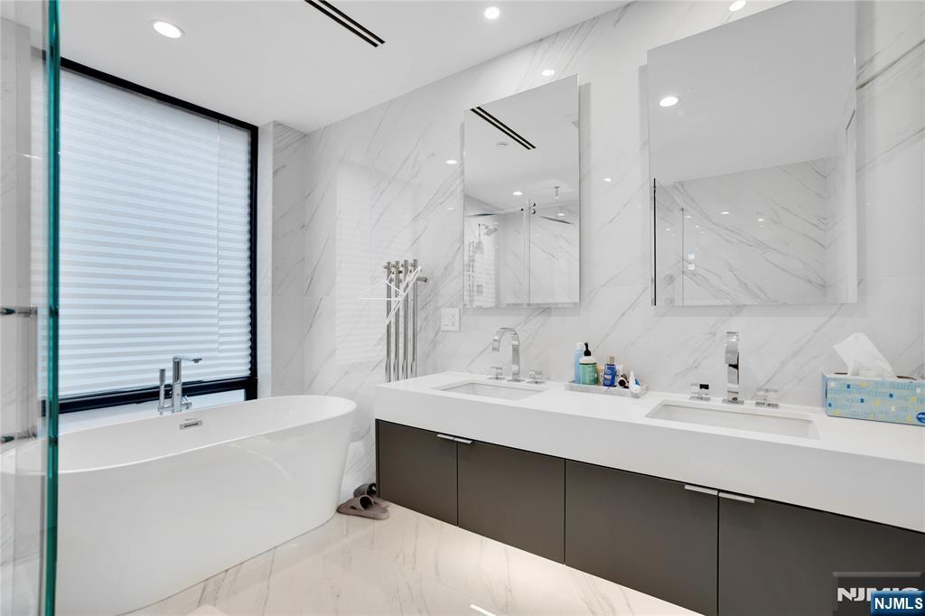7 Adelaide Place Edgewater, NJ 07020 - Photo 14 of 24 a bathroom with a double vanity sink mirror and bathtub