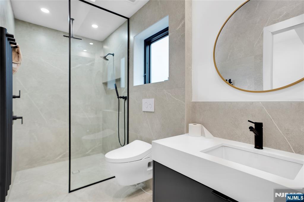 7 Adelaide Place Edgewater, NJ 07020 - Photo 18 of 24 a bathroom with a sink a toilet and a mirror