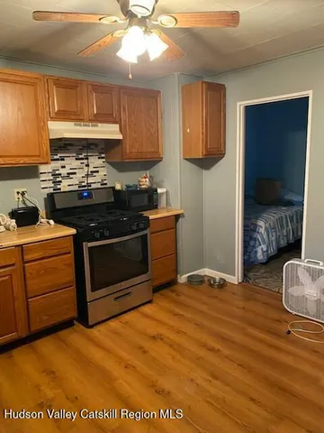 a kitchen with stainless steel appliances granite countertop a stove a sink and a microwave