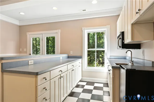 a kitchen with a checkered floor and white cabinets