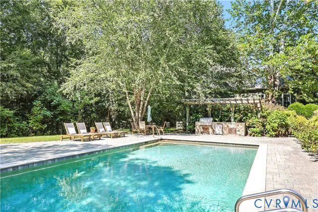 a view of a backyard with lawn chairs and a fire pit