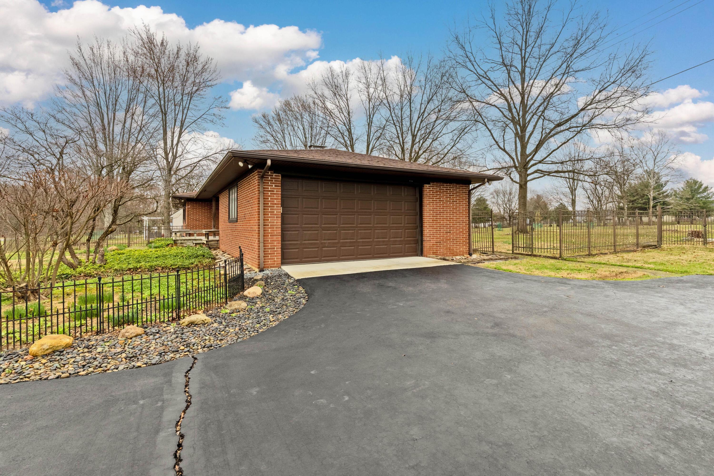 6982 Lee Road Westerville, OH 43081 - Photo 61 of 71 • 2+ car attached • Epoxy flooring • Pull-down attic access • Man door • Wall shelves • Brick walls • New Liftmaster® electric door opener ~ 2020 • New garage door ~ 2020