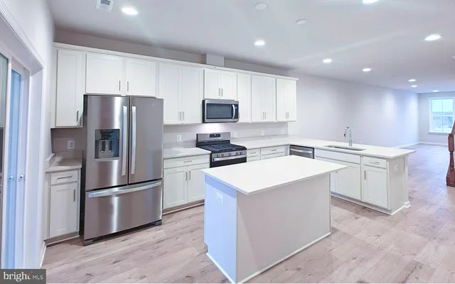 a kitchen with stainless steel appliances a refrigerator stove microwave and sink