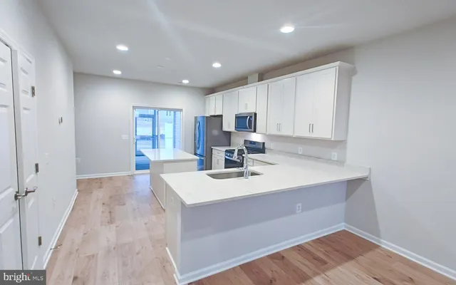 a view of kitchen with sink microwave and refrigerator