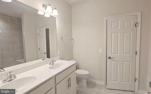 a bathroom with a sink a toilet and a mirror