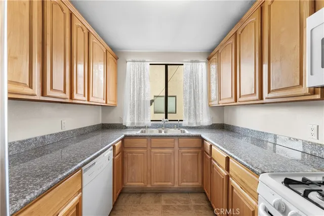 a kitchen with stainless steel appliances granite countertop a sink a stove and cabinets