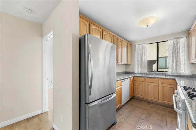 a kitchen with stainless steel appliances granite countertop a refrigerator and a sink