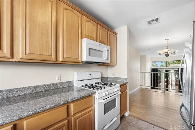 a kitchen with stainless steel appliances granite countertop a stove a sink and a microwave