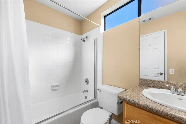 a bathroom with a granite countertop sink toilet mirror and a bathtub