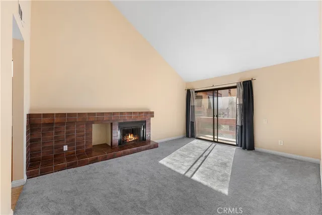 a view of an empty room with a fireplace and a window