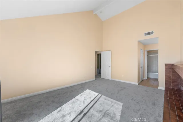 an empty room with fireplace and windows