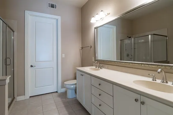 a bathroom with a double vanity sink a toilet and a mirror