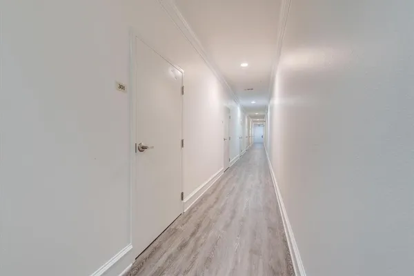 a view of a hallway with wooden floor