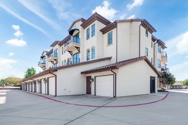 a view of a white house with large windows and a small yard