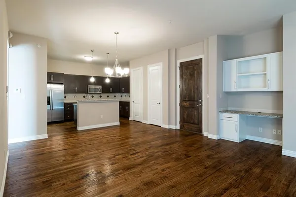 a view of a kitchen with a sink and dishwasher a refrigerator with wooden floor
