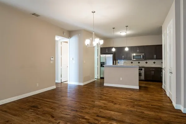 a kitchen with stainless steel appliances granite countertop a refrigerator a sink dishwasher a stove and a refrigerator